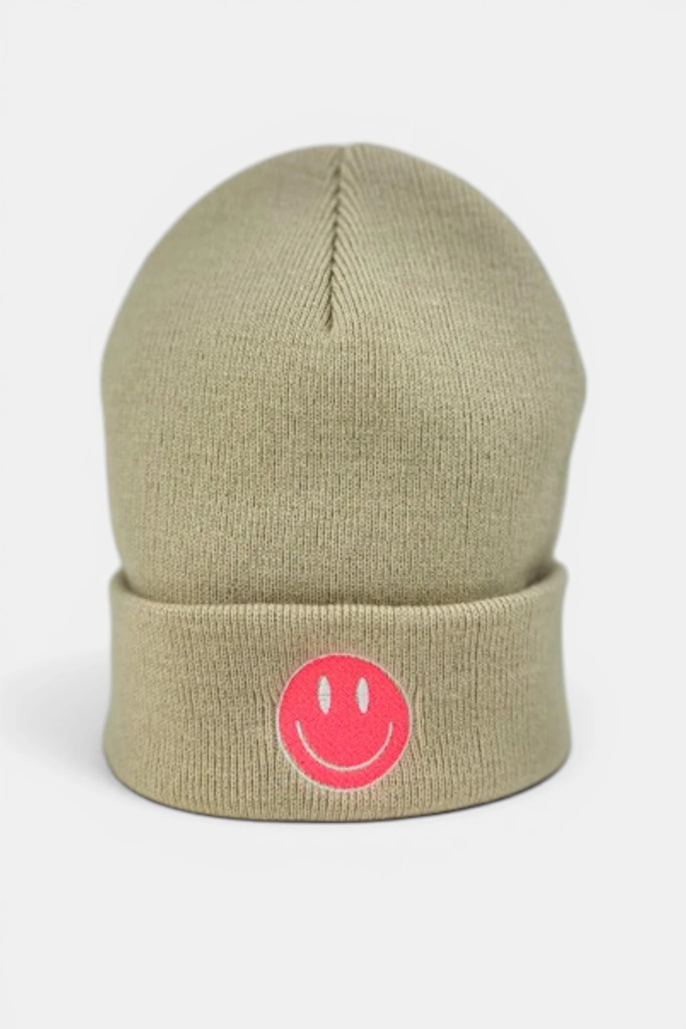 A beige beanie hat featuring a folded cuff with a fluorescent coral orange embroidered smiley face logo, set against a plain light gray background.