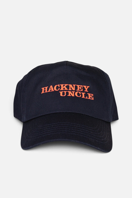 A navy blue baseball cap with 'HACKNEY UNCLE' embroidered in fluorescent coral orange across the front, shown against a light grey background.