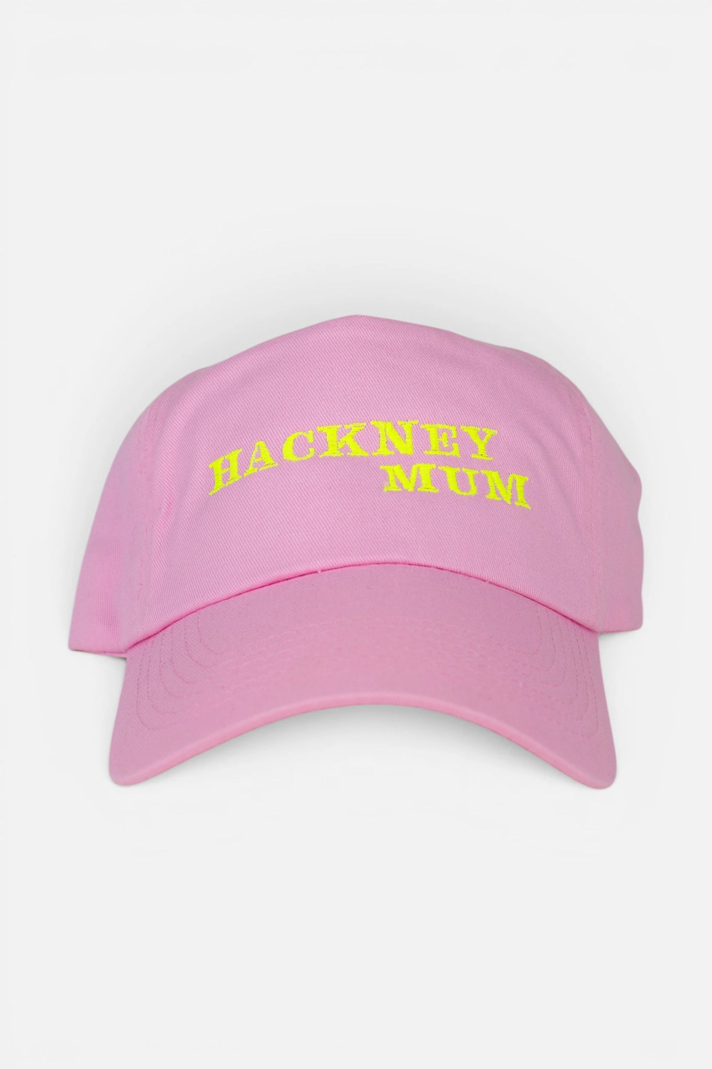 A pink baseball cap with 'HACKNEY MUM' embroidered in yellow across the front, shown against a plain white background.