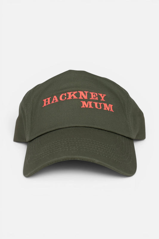 An olive green baseball cap with 'HACKNEY MUM' embroidered in fluorescent coral orange across the front, shown against a plain light gray background.